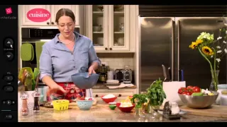 Capture du lecteur Interlude : &agrave; gauche une colonne de commandes noire &mdash; logo interlude, fl&egrave;ches &laquo; channel &raquo; haut et bas, volume, lecture &mdash; et &agrave; droite une &eacute;mission de cuisine, une femme en chemise bleue vidant un saladier sur un plan de travail couvert d'ingr&eacute;dients, sous un cartouche rose marqu&eacute; &laquo; cuisine &raquo;.
