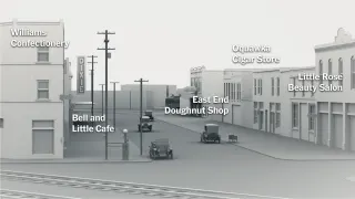 Reconstruction en trois dimensions, tout en gris, d'une rue commer&ccedil;ante de Greenwood en 1921 : devantures et voitures d'&eacute;poque, chaque commerce nomm&eacute; par une &eacute;tiquette &mdash; Williams Confectionery, East End Doughnut Shop, Little Rose Beauty Salon